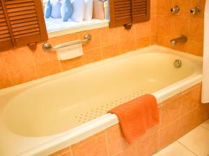 a bath tub in a bathroom with an orange towel at Asia Pattaya Hotel in Pattaya South