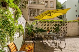 een tafel en stoelen met een gele parasol op een patio bij Prague Retreat Apartment in Praag