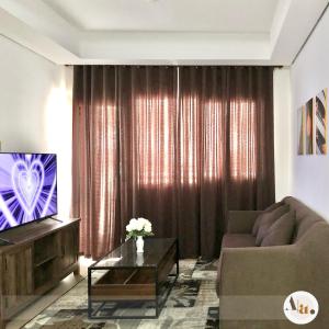 a living room with a couch and a television at Abby's condotel in Manila