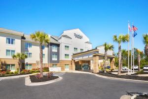 a hotel with palm trees in front of a parking lot at Fairfield Inn & Suites By Marriott Hinesville Fort Stewart in Hinesville