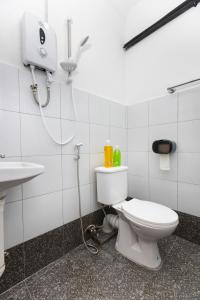 La salle de bains est pourvue de toilettes blanches et d'un lavabo. dans l'établissement The Bahari Lodge @ Georgetown, à George Town