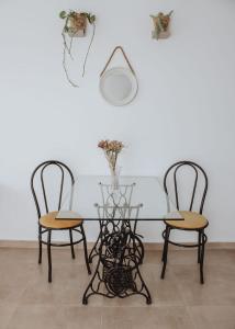 een eettafel met 2 stoelen en een vaas bij Yellow in San Miguel de Tucumán