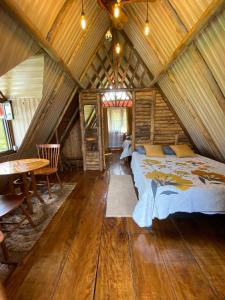1 dormitorio en una cabaña de madera con 1 cama y 1 mesa en Cabaña El Viejo del Monte, en Venecia
