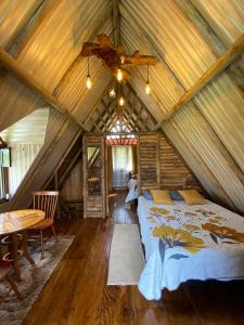 1 dormitorio en una cabaña de madera con cama y techo en Cabaña El Viejo del Monte, en Venecia