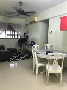 a person in a living room with a table and chairs at 9293 Puncak Nearby Bukit Bendera in George Town
