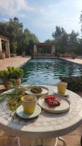 una mesa con platos de comida junto a una piscina en Sel d Ailleurs, Atlas Mountain Retreat - adults only, en Ouirgane