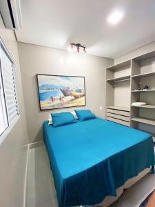 a bedroom with a blue bed in a room at Penhasco Residences in Chapada dos Guimarães