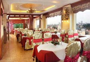 une salle à manger avec des tables et des chaises dans un restaurant dans l'établissement Hoa Hồng Hotel 2 - 102 Xã Đàn - by Bay Luxury, à Hanoï