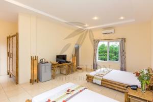 ein Schlafzimmer mit einem Bett und einem TV in einem Zimmer in der Unterkunft Tre Nguồn Thiên Cầm Hotel&Resort in Hưng Long