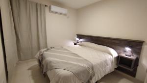 1 dormitorio con 1 cama grande y cabecero de madera en Vid_y_Olivo. Cómodo departamento en el centro de Maipú en Maipú