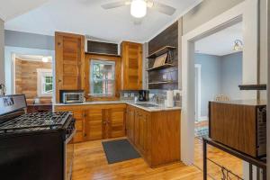 a kitchen with wooden cabinets and a stove top oven at Comfy Cuse home close to SU in Syracuse