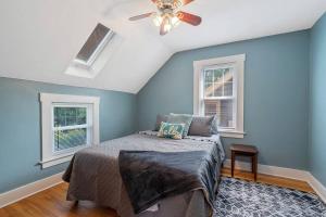 a bedroom with blue walls and a bed with a ceiling fan at Comfy Cuse home close to SU in Syracuse