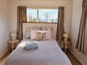 um quarto com uma cama grande e uma janela em Seaside Tahuna em Nelson