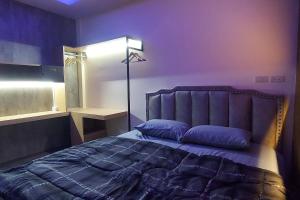 una camera da letto con un letto con pareti viola e una lampada di Lanmuanghouse a Chiang Rai