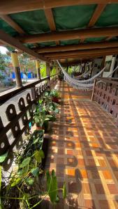 Un balcón con una hamaca y plantas. en La Casa Del Arbol, en Olón
