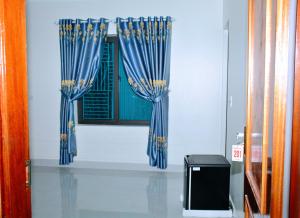 two blue curtains on a window in a room at Vinh Airport Hotel in Vinh
