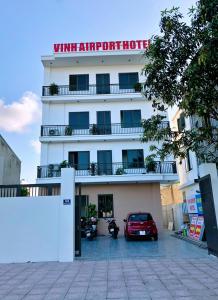 a white hotel with a car parked in front of it at Vinh Airport Hotel in Vinh