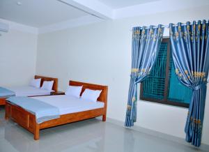 a bedroom with two beds and a window at Vinh Airport Hotel in Vinh