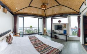 a bedroom with a large bed and large windows at Phuong Nam Hotel in Sa Pa