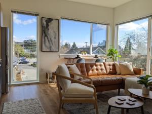a living room with a leather couch and large windows at A premier luxurious smart condo with parking in Seattle