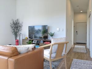 a living room with a couch and a tv at A premier luxurious smart condo with parking in Seattle