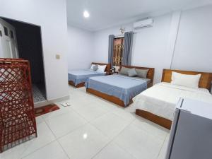 a hotel room with two beds and a window at Orchid 101 in Kampot