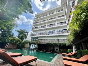 a hotel with a swimming pool in front of a building at DACO Hotel in Siem Reap