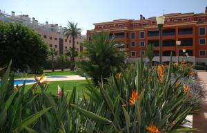 Un jardín frente a un edificio con árboles y flores. en Apartment De Jardines, en Denia