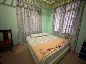 Raudah Homestay في كوتا بْهارو: سرير صغير في غرفة مع الستائر وسيدكس السرير سيدكس