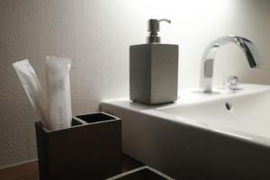 a bathroom with a sink and a holder with a practition at Acoustic GARAGE in Tokyo