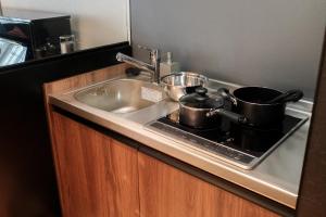 two pots and pans sitting on a kitchen sink at Acoustic GARAGE by Tranova in Tokyo