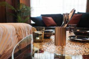 a glass table with glasses and utensils on it at Acoustic GARAGE by Tranova in Tokyo