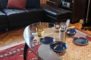 a glass table with plates and utensils on it at Acoustic GARAGE by Tranova in Tokyo