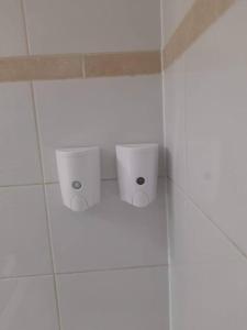 een badkamer met 2 toiletten in een witte betegelde muur bij Apart hotel en el corazon de Providencia,Stgo in Santiago