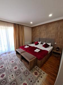 a bedroom with a large bed with red pillows at Hotel Mountain Mestia in Mestia