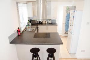 a kitchen with a counter top and two stools at NEW 2BD Detached House in the Heart of Lincoln in North Hykeham