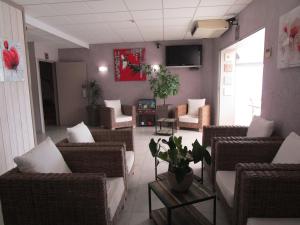 una sala de estar con sillas de mimbre y sofás en Le Maray, en Le Grau-du-Roi