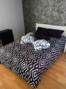 ein Bett mit zwei Kissen darauf in einem Schlafzimmer in der Unterkunft Paris centre in Le Raincy