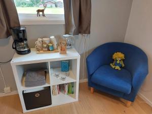 een blauwe stoel naast een witte tafel bij Guestrooms at Forest Family Home in Ytterhogdal