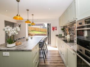 uma cozinha com armários brancos e uma grande ilha em Stag Cottage em Poole