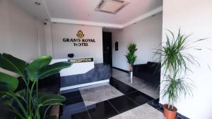 GümüşyakaGRANDROYAL HOTEL的大堂种植了植物,标牌上写着宏伟的房间酒店