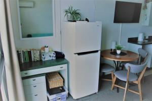 a kitchen with a white refrigerator next to a table at Treat yourself, fun in the sun at The Aquarius in North Ward