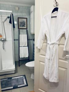 a bathroom with a white robe hanging on a door at Apartments At The Sentrum in Kristiansund