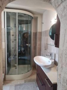 ein Bad mit einer Glasdusche und einem Waschbecken in der Unterkunft Trullo Mancini in Locorotondo