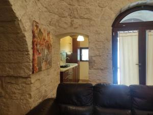 ein Wohnzimmer mit einem Sofa und einer Steinmauer in der Unterkunft Trullo Mancini in Locorotondo