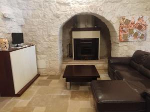 ein Wohnzimmer mit einem Sofa und einem Kamin in der Unterkunft Trullo Mancini in Locorotondo