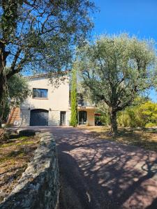 a house with a tree in front of a driveway at Villa Fadeta in Gattières