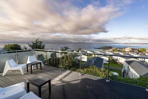 a balcony with white chairs and a view of the ocean at Lanyon in St Ives