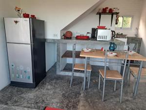 Juliet Home Samui في Ban Lamai: مطبخ مع ثلاجة وطاولة مع كراسي