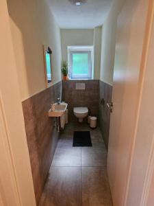 a bathroom with a toilet and a sink at Ferienwohnung Petra in Kössen